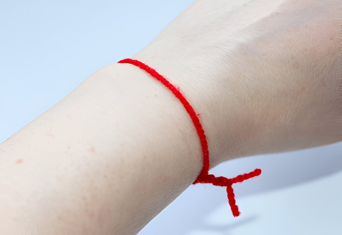 Personne recevant un bracelet en fil rouge