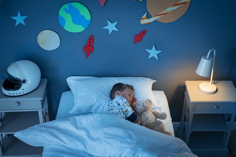 Enfant rêvant dans une chambre à thème spatial