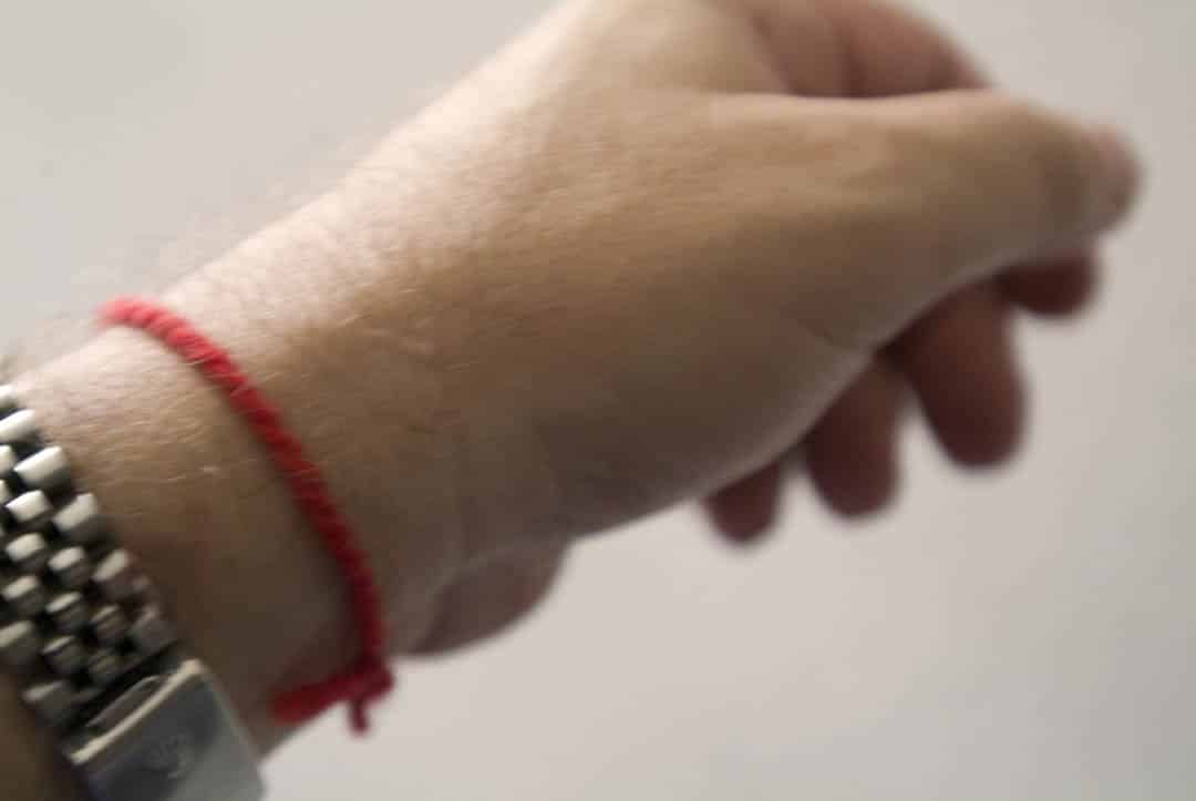 Femme méditant avec un bracelet en fil rouge