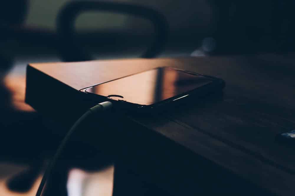 Téléphone branché la nuit sur une table de chevet