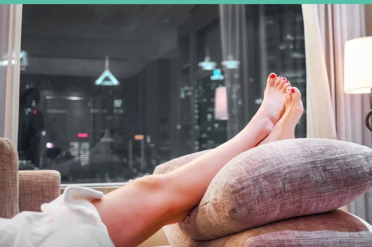 Femme surélevant ses jambes avec un coussin