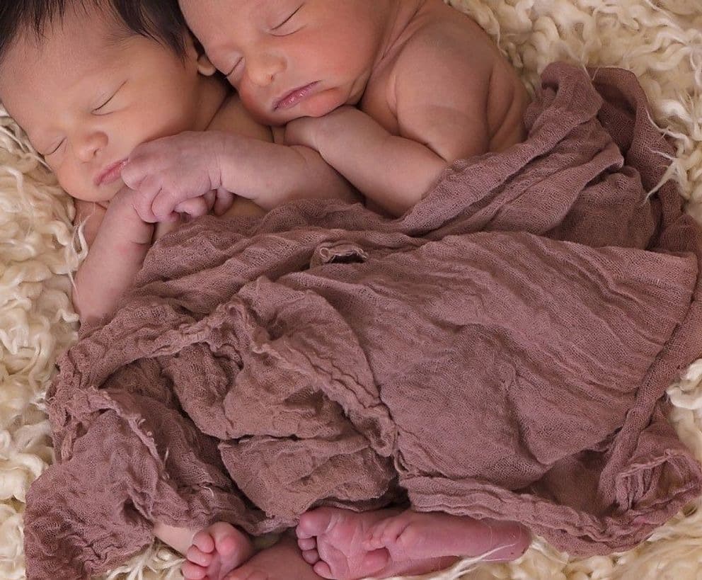 Femme tenant deux bébés dans ses bras