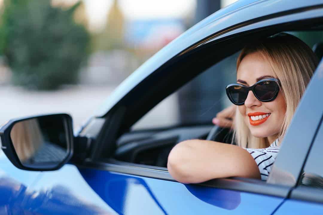 Jeune femme conduisant une voiture avec assurance
