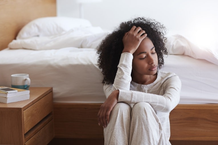 Femme épuisée s'appuyant contre un mur