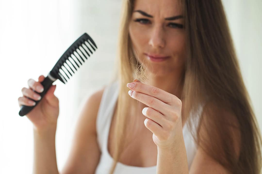 Femme constatant une chute de cheveux importante