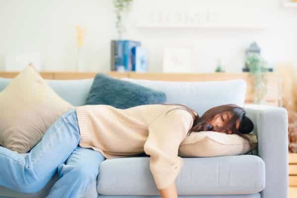 Femme épuisée dormant sur son canapé