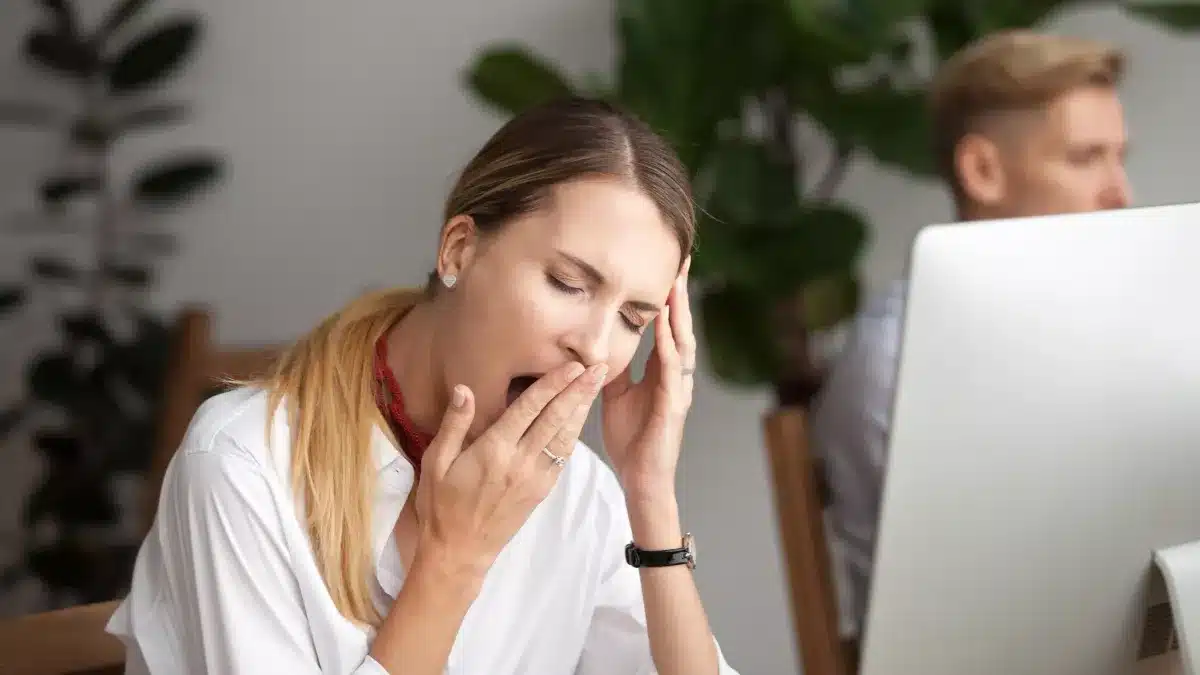 Femme épuisée posant sa tête sur un bureau