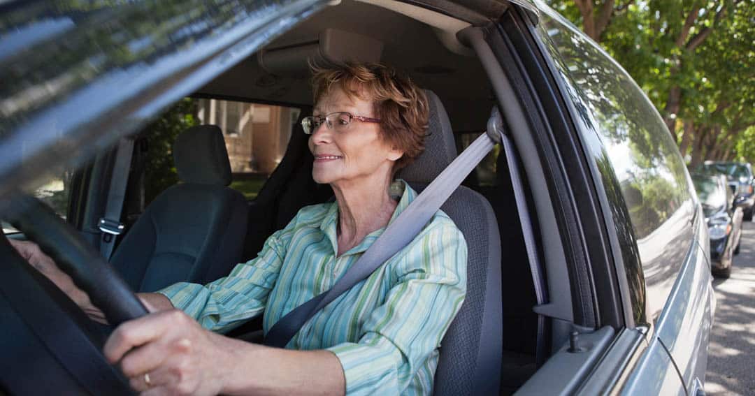 Couple de seniors souriants en voiture