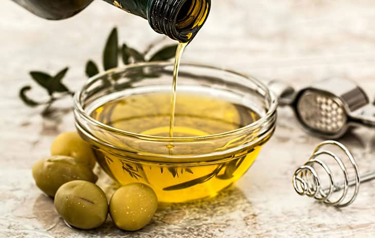 Bouteille d'huile d'olive et olives fraîches