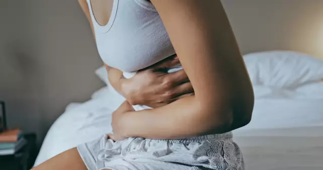 Femme appliquant une bouillotte sur son ventre