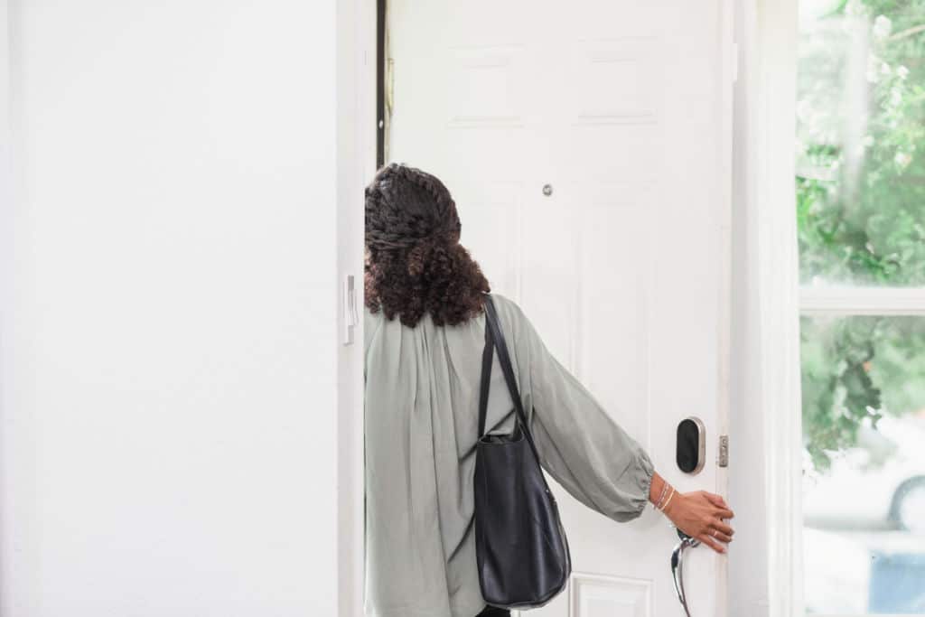 Jeune femme quittant une maison, perdue dans ses pensées
