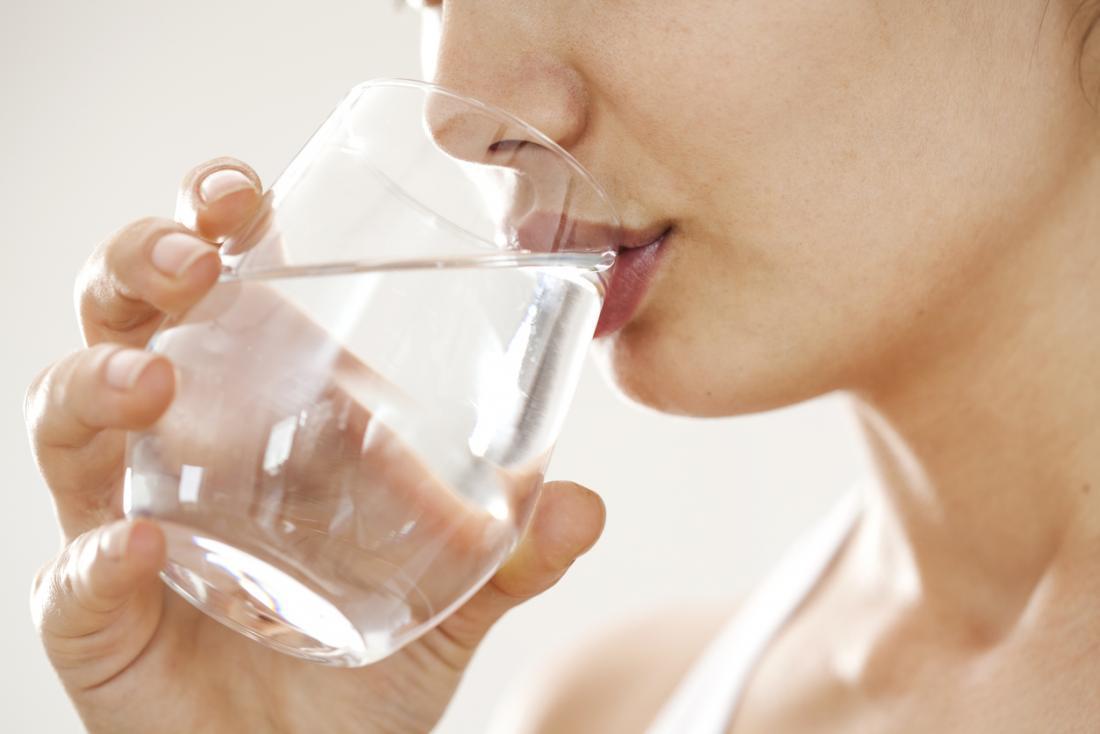 Femme buvant de l'eau le matin