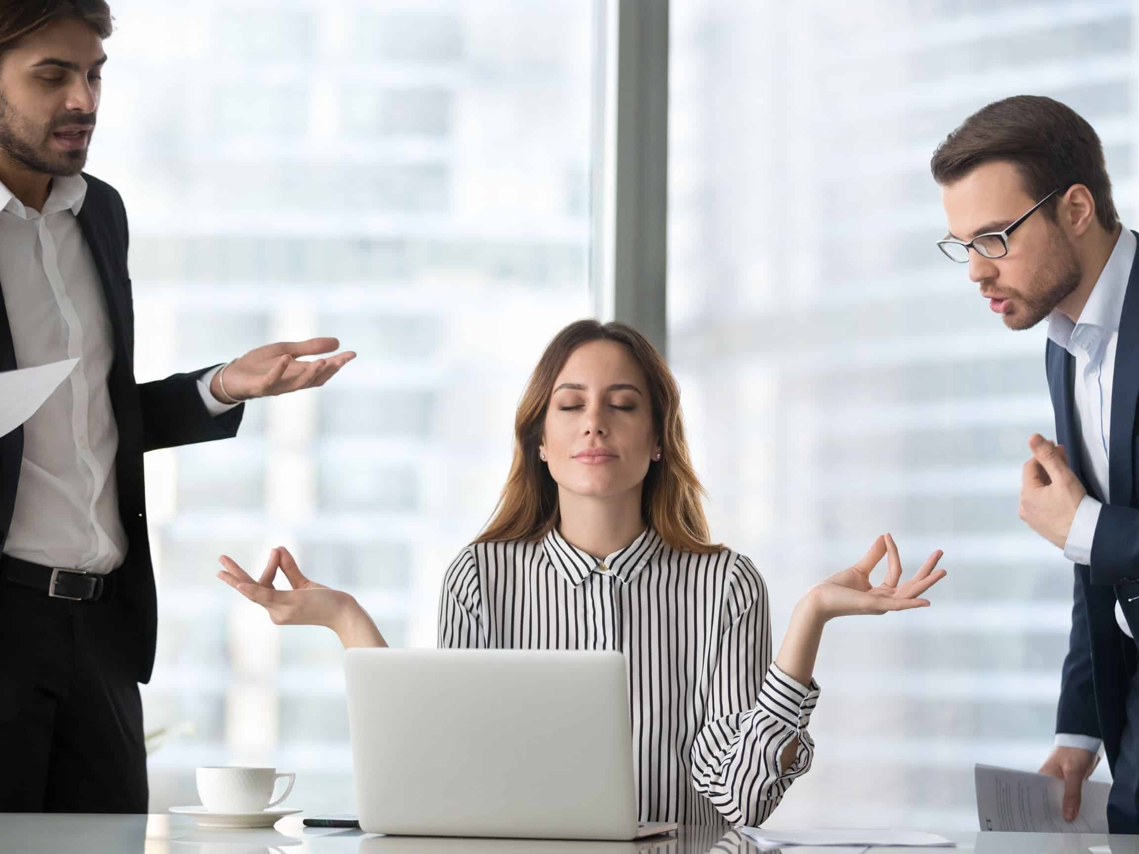 Femme zen en entreprise ignorant des provocations
